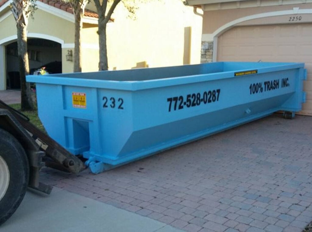 Blue dumpster in residential driveway