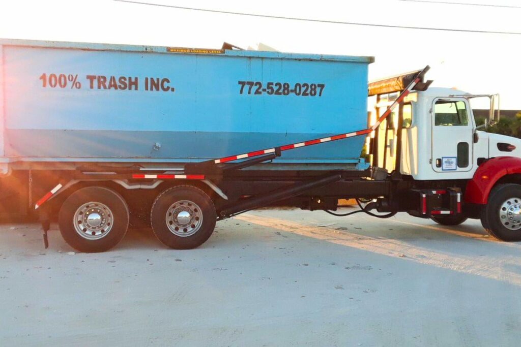 Trash truck with blue container in sunlight