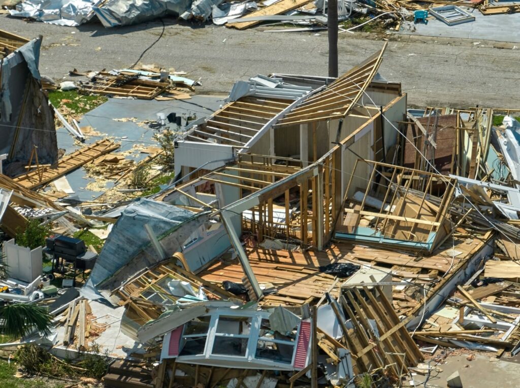 Hurricane damaged house with debris scattered everywhere.