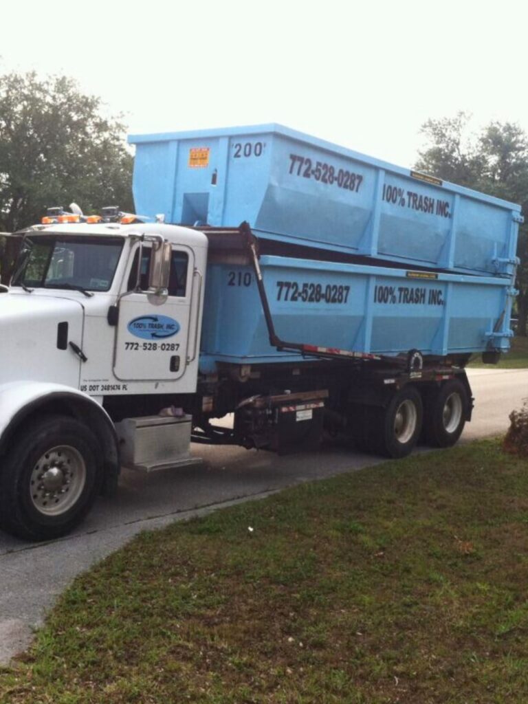 Truck with blue dumpsters from trash company.