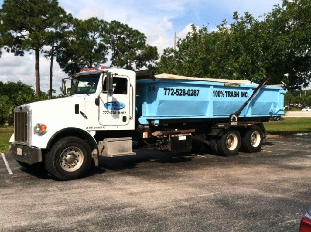 Dump truck parked outdoors with trees in background.