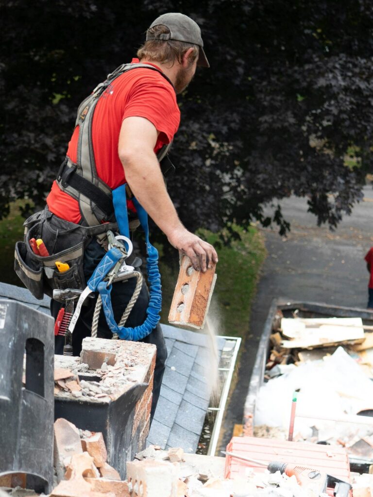 Construction worker repairing chimney on roof